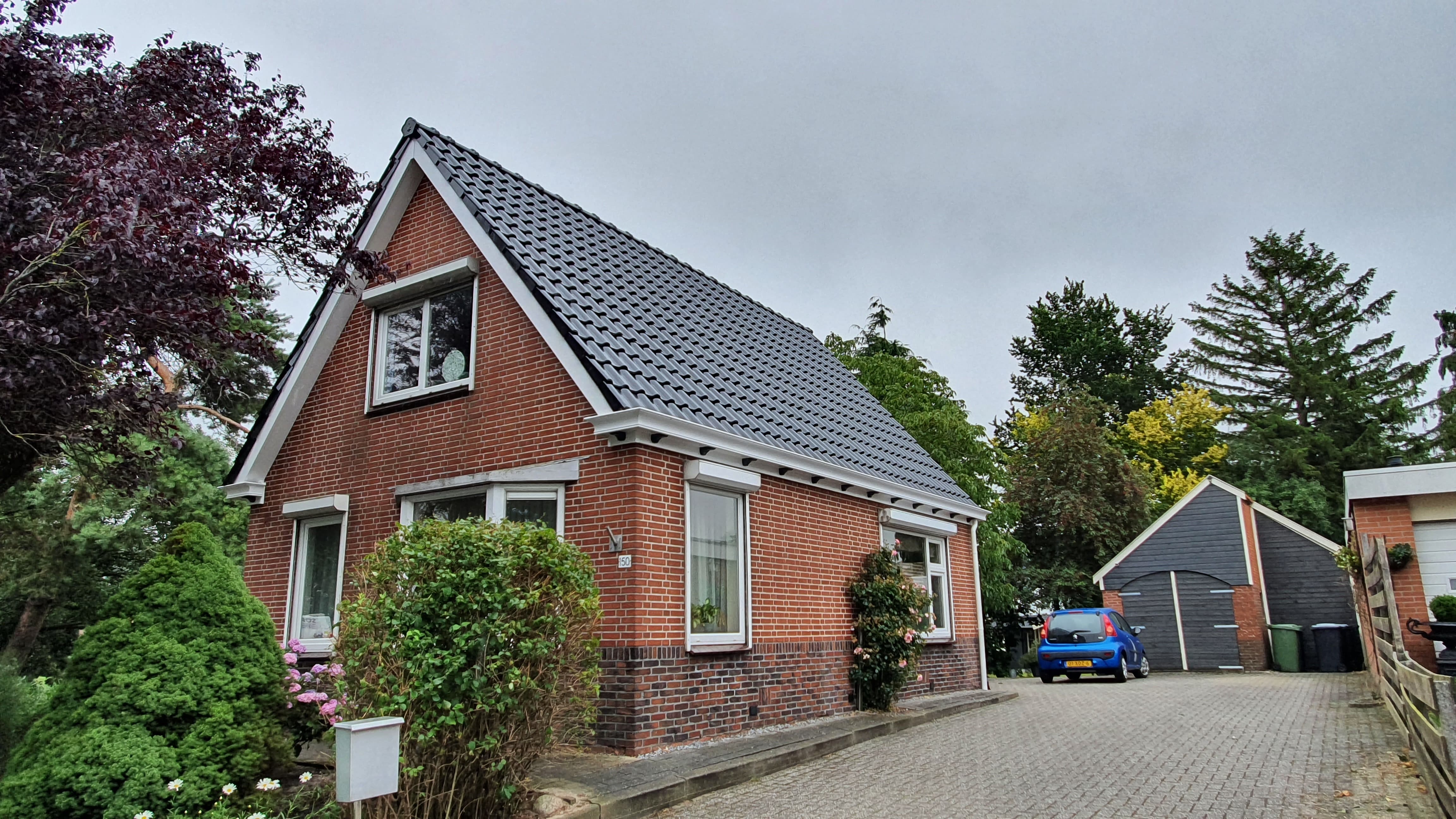 Woning met nieuw pannendak en vernieuwde boeidelen en goten
